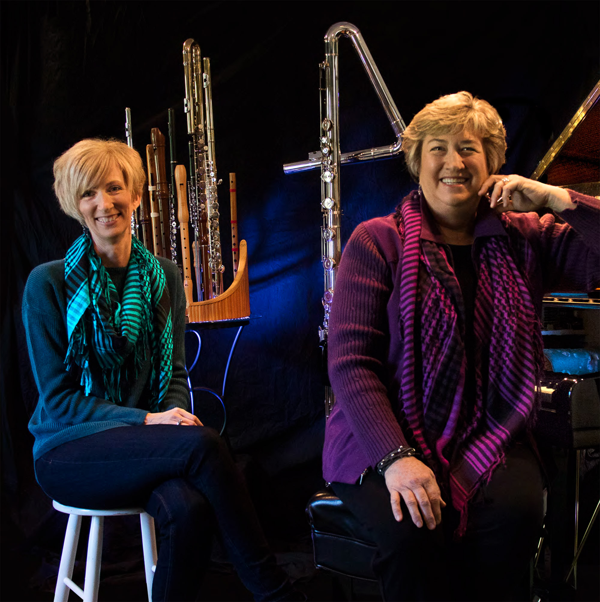 two women, one at a piano, sit in front of a row of woodwind instruments